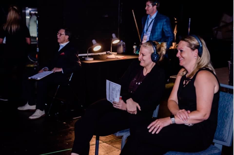 Susan and colleagues working backstage with headphones and a script