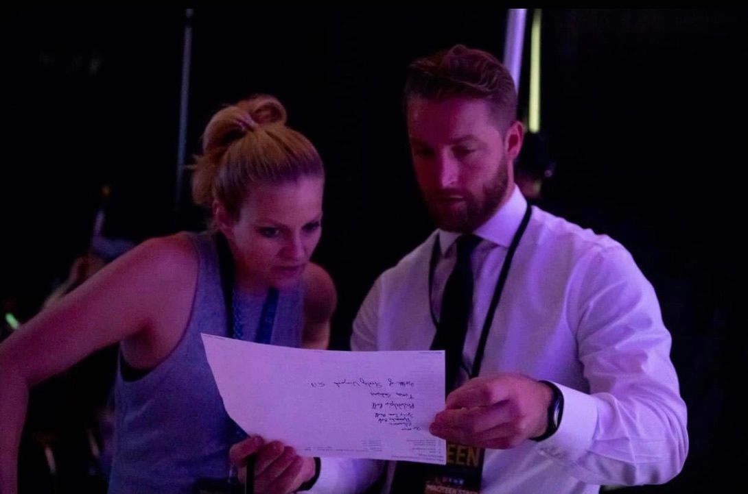 Susan reviewing a handwritten script with a colleague backstage