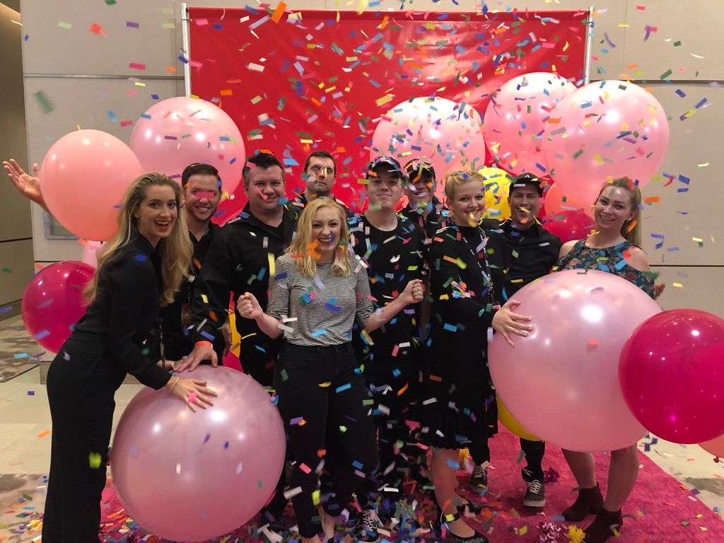 Production crew celebrating with balloons and confetti
