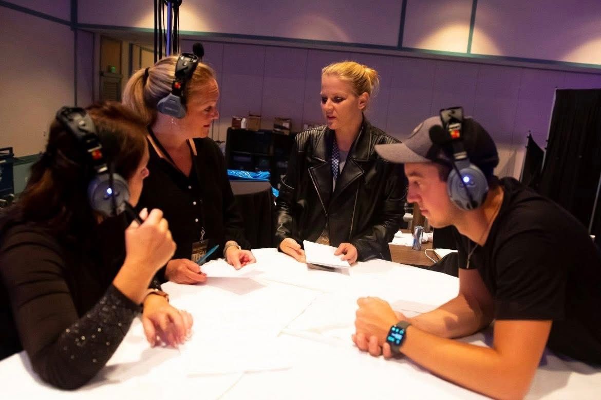 Susan briefing crew members around a production table